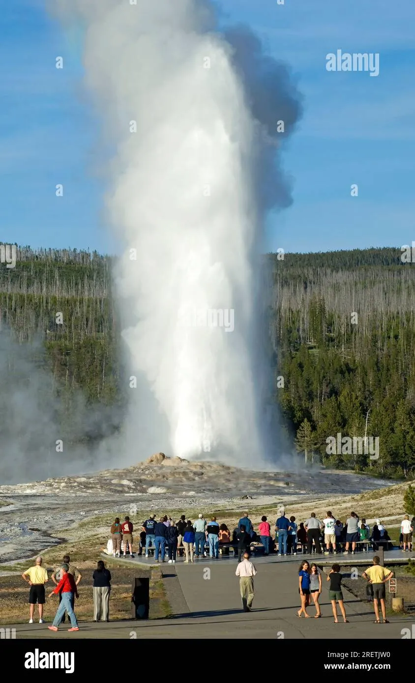 Visitors watching Old Faithful geyser eruption at Yellowstone National Park