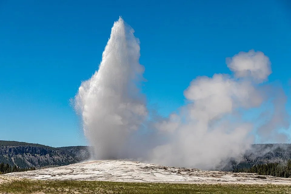 Old Faithful geyser erupting in Yellowstone National Park during a guided tour
