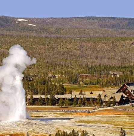 Old Faithful Inn exterior view with mountains in background