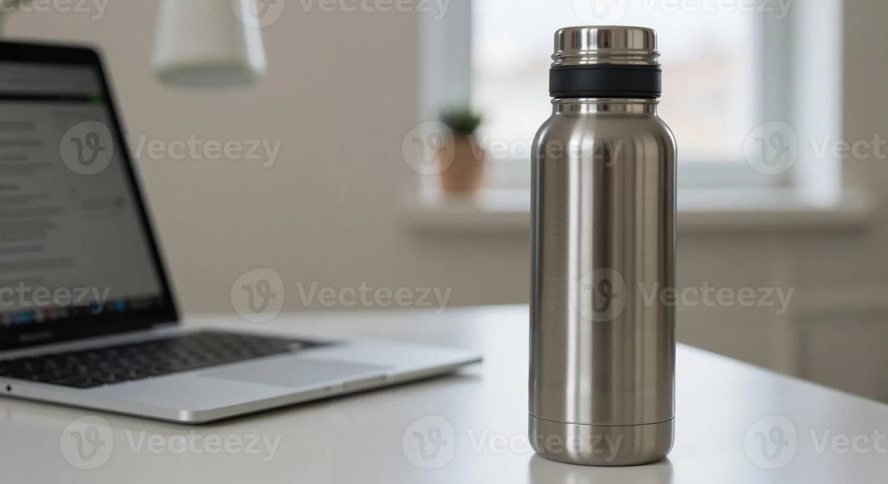 Professional stainless steel water bottle on office desk with computer and documents